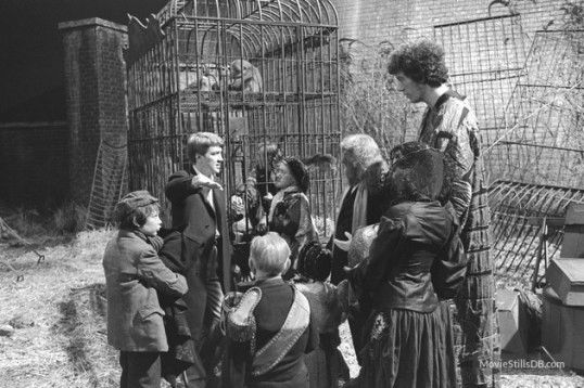 Behind the scenes of The Elephant Man. Kenny Baker is standing in front of the cage.